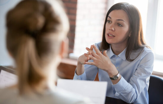 Business woman speaking in meeting to other participants