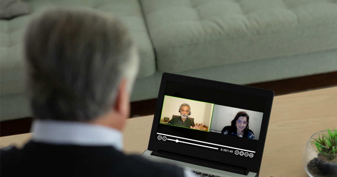 Man looking at laptop screen where a video conference is playing