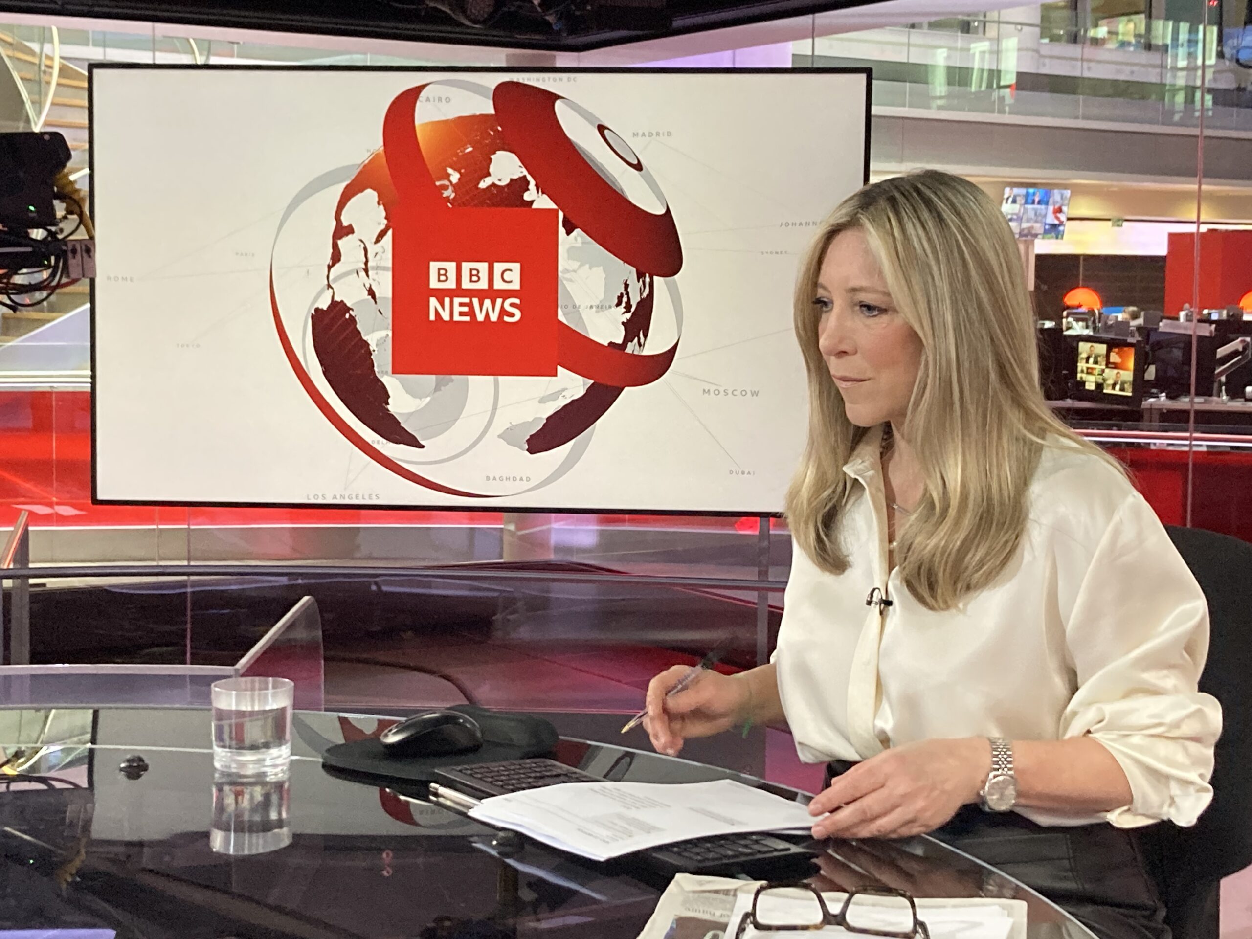 Joanna Gosling presenting the news in BBC studio looking at the notes in front of her