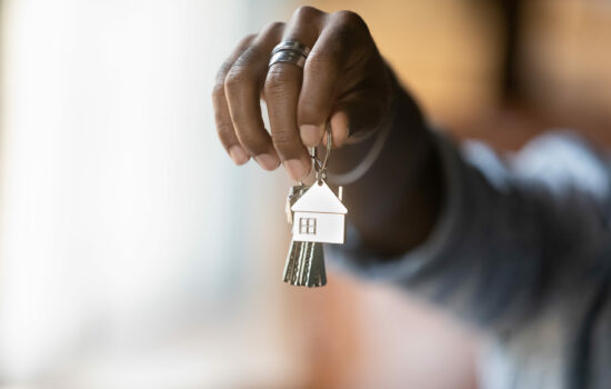 Property agent holding out a set of housekeys only his hand is visible