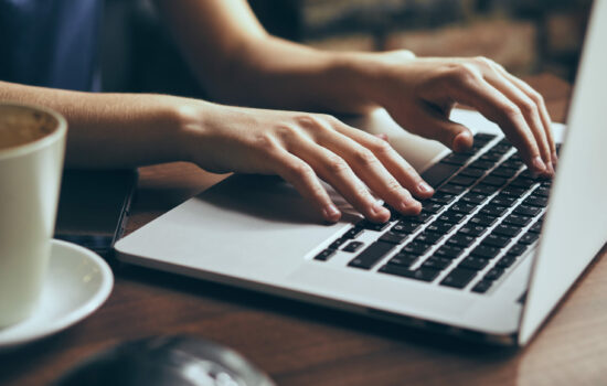 Woman's hands typing on laptop